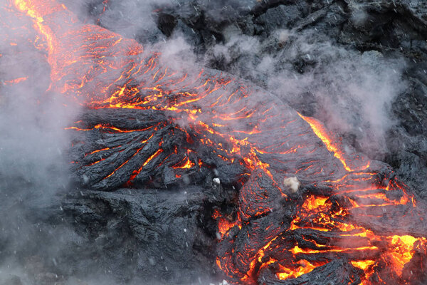A closeup shot of the smoke and the hot lava of a volcano