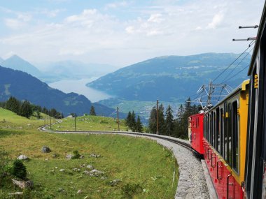 Açık havada güneşli bir yaz günü, tren rayların yanından geçiyor.