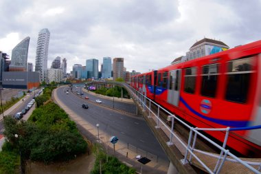 Doğu Hindistan DLR İstasyonu 'ndan Kanarya Rıhtımı' na bakan kırmızı bir tren istasyondan ayrılıyor.