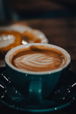 Bir kafede mavi bir fincanda güzel bir lale latte sanatının yakın plan fotoğrafı.