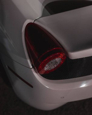 Beyaz bir spor arabanın arka lambasına yakın çekim.