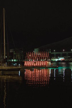 Gece Tromso limanındaki saunanın dikey görüntüsü. Norveç