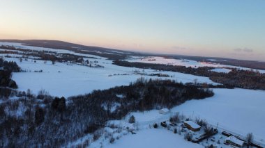 Karla kaplı arazi ve evlerin havadan görünüşü