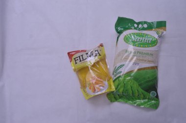 Beyaz arka planda paketlenmiş pirinç ve pişirme yağı.