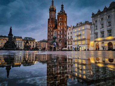 Polonya, Krakow 'da bulutlu bir arka planda Krakow ana meydanının nefes kesici alçak açılı çekimi.