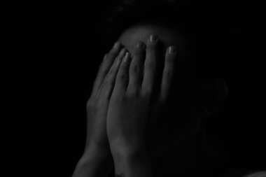 Yüzünü elleriyle kapatan bir adamın yakın plan gri pulu.