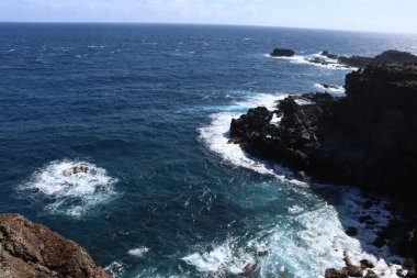 Güneşli bir günde, kayalık bir sahil.