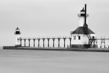 Gri tonlu güzel bir iskeledeki deniz feneri manzarası.
