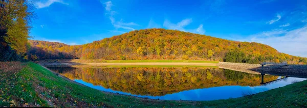 湖畔の紅葉に覆われた森の山のパノラマビュー — ストック写真