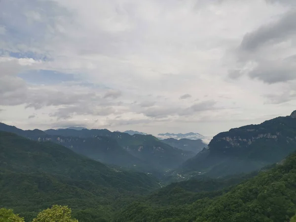 明るい空の下 鬱蒼とした森に囲まれた美しい山の風景 — ストック写真