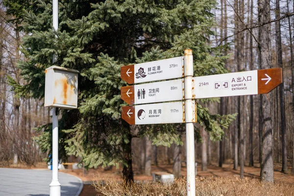 Yol kenarındaki paslı eski bir tabelayı yakından çek ve üzerine Çince harfler yaz.