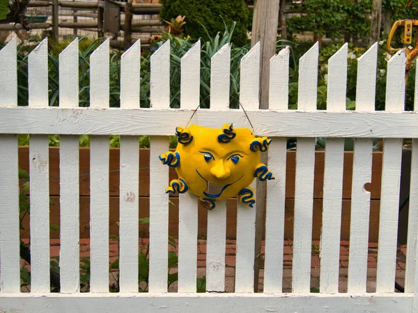 白い木製の柵に掛けられた抽象的な太陽の装飾の閉鎖 — ストック写真
