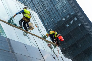 Chongqing, Çin-20 Temmuz 2021: Yüksek katlı dış binanın pencerelerini temizleyen Çinli işçi.