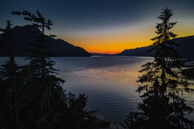Gökyüzünde güzel bir günbatımı sırasında kırsal bir bölgedeki göl manzarası