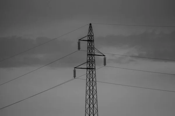 Bulutlu Gökyüzüne Karşı Bir Iletim Kulesinin Gri Tonlu Görüntüsü — Stok fotoğraf