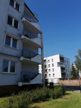 Güneşli bir günde apartmanların dikey görüntüsü ve Zegrze bölgesindeki yeşil çimenler.