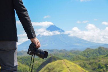 Arka planda yeşilliklerle çevrili Mayon volkanı olan bir el manzarası.