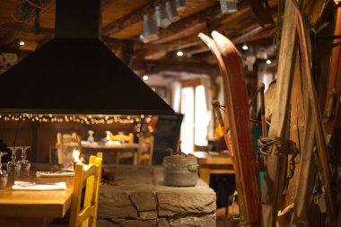 Sarı sandalyeli ve arka planında çekiç sobası olan bir masanın güzel bir iç çekimi.