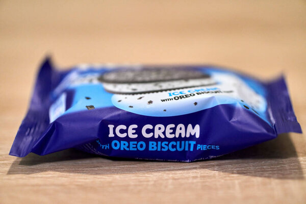 Крупный план сэндвича с печеньем Oreo Biscuit на деревянной поверхности в ярком свете с размытым фоном. Познань, Польша