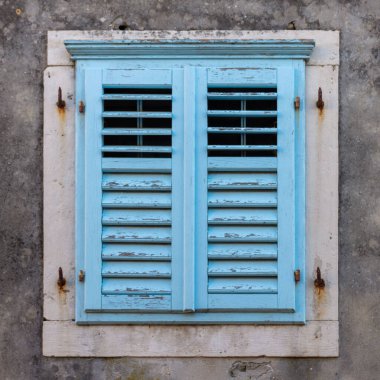 Bir binanın eski mavi ahşap penceresinin yakın çekimi.