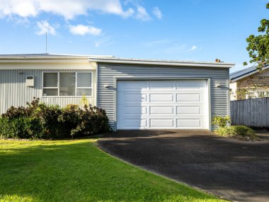 View of suburban house with garage. Auckland, New Zealand - May 20, 2022 clipart