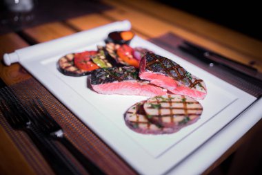 Izgara patates ve domatesli ızgara somon filetosu.