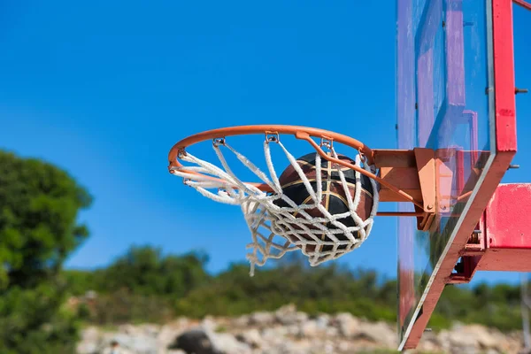 basketball ball on an outdoor basketball court, after basketball player shot