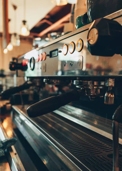 A vertical closeup of a professional coffee machine in a cafe