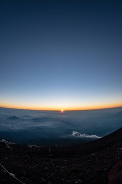 Japonya 'daki sisli dağın üzerinde güzel bir gün batımı manzarası.