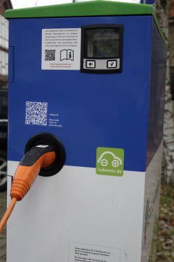 30 Ocak 2022, Bad Salzdetfurth, Lower Saxony, Almanya, White and Blue EVI elektrikli araçlar için sağdaki turuncu eklentili şarj istasyonu