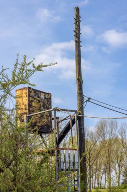 Mavi gökyüzü arkaplanlı bir elektrik direğinin dikey görüntüsü