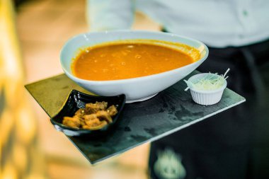 Elinde vejetaryen çorba kasesi tutan tanınmamış bir insan.