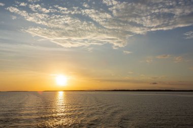 Amazon yağmur ormanlarındaki Amazon nehrinde gün batımında mavi gökyüzünün güzel manzarası, Brezilya.