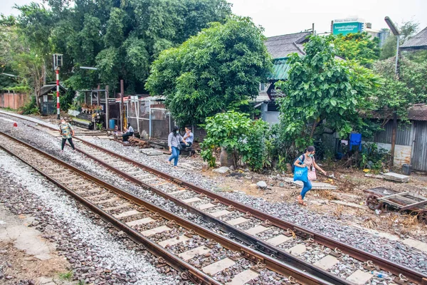 Tayland 'ın güneydoğusundaki Bangkok banliyösündeki bir tren istasyonunun raylarındaki Taylandlılar