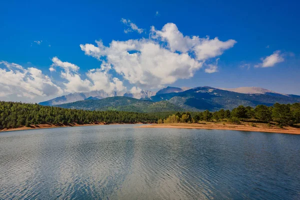 Sahilde tepelere ve gökyüzüne karşı yeşil bitki örtüsü ve gölü olan güzel manzara..