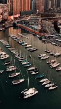 İkonik Hong Kong Victoria Limanı 'na demirlemiş teknelerin ve günbatımında ufuk çizgisinin hava görüntüsü.