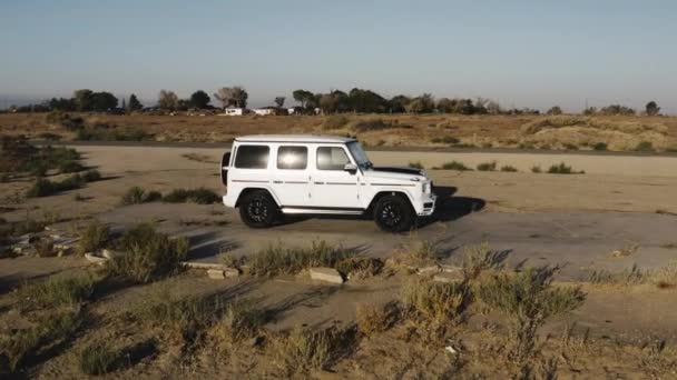 ホワイト メルセデスGワゴンが砂漠をドライブ — ストック動画