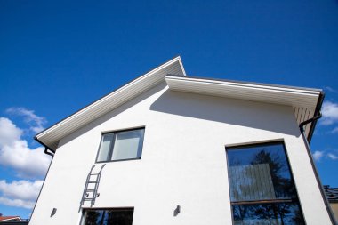 Mavi gökyüzünün altındaki beyaz bir binanın güzel alçak açılı görüntüsü.