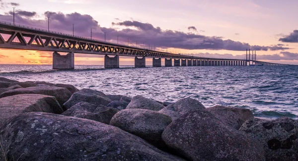 İsveç ile Danimarka arasındaki Oresundsbron köprüsünün güzel bir manzarası Gün batımında bulutlu bir mor gün batımı gökyüzünün altında