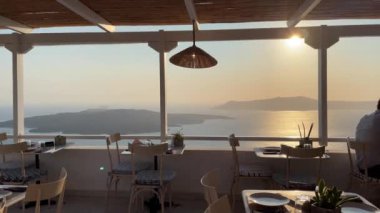 Yunanistan 'ın Santorini kentindeki bir sahil restoranında yemek yiyen insanlar