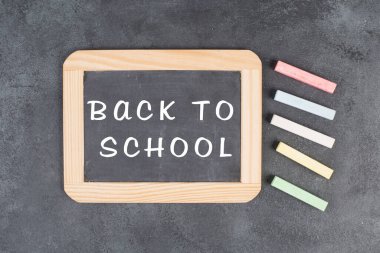 Metni okula geri getiren yazı tahtası, eğitim konsepti, renkli tebeşirler