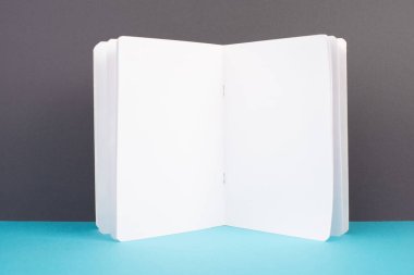 Beyaz kitap sayfası, okul ve eğitim kavramı, metin için kopyalama alanı, boş kağıt, gri ve mavi arkaplan