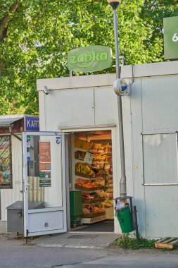 Orla Bialego bölgesinde açık kapısı olan küçük bir Zabka marketinin dikey görüntüsü.