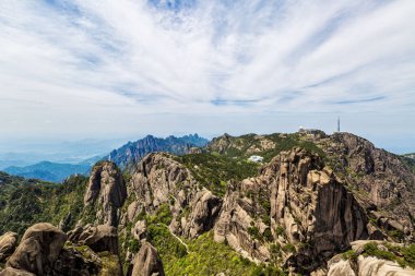 Huangshan Dağı 'nın manzarası Anhui, Çin' de mavi gökyüzüne karşı ağaçlarla kaplı.