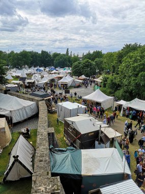 Almanya 'da bir sürü insan ve çadırın bulunduğu büyük bir ortaçağ fuarının dikey çekimi.