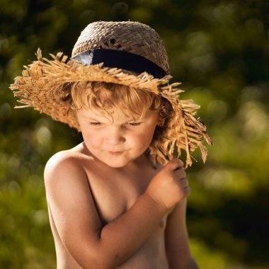 Yazın hasır şapka takan sarışın, beyaz bir çocuk.