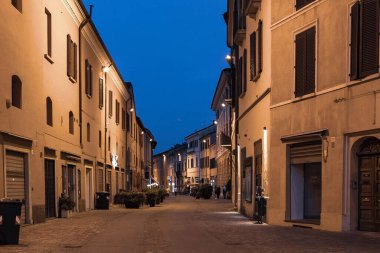 İtalya 'nın Imola şehir merkezinde gün batımında dar bir caddenin güzel bir manzarası.