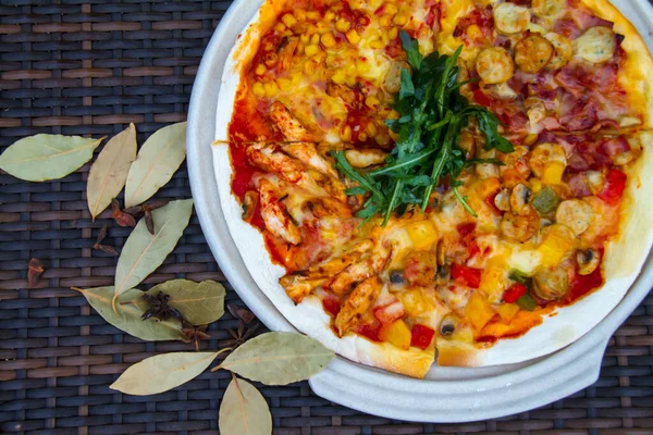 A beautiful shot of a tasty pizza with corns, chicken and ketchup