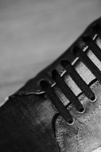 Siyah beyaz spor ayakkabılı, kullanılmış bir adamın dikey çekimi.