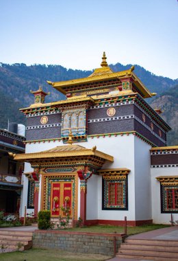 Bir Budist tapınağının arka planında dağlar olan güzel dış görünüşünün dikey görüntüsü.